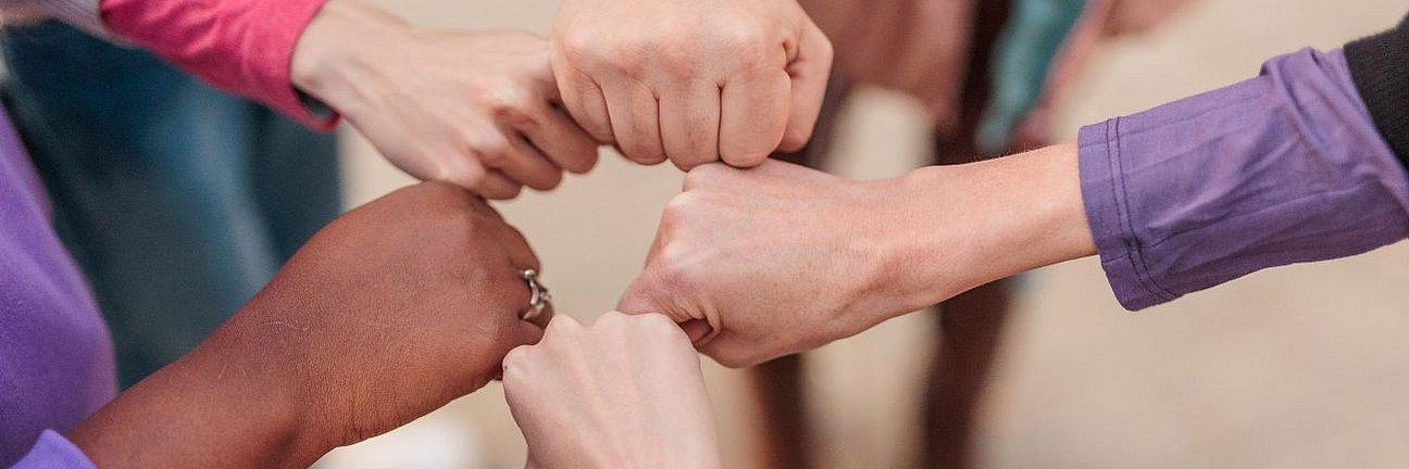 Mehrere Frauenfäuste bilden ein Zentrum .